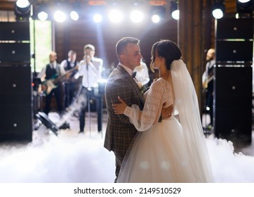 Blur Of Faceless Musician Standing And Singing Song With Band While Newlyweds, Dancing First Wedding Dance In Centre Of Hall Among Smoke Effects 