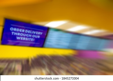 Blur Of A Fast Food Takeout Menu Board. First Panel Says ORDER DELIVERY THROUGH OUR WEBSITE. Rest Of Panels Not Readable. Takeout Not Identifiable.