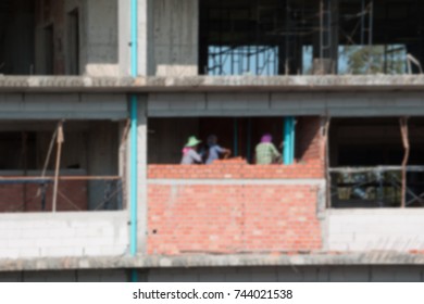 Blur Of  Female Worker Bricklayer Laying Brick A Wall Construction In Industrial  Building Site