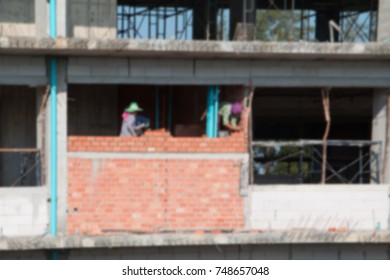 Blur Of  Female Worker Bricklayer Laying Brick A Wall Construction In Industrial  Building Site