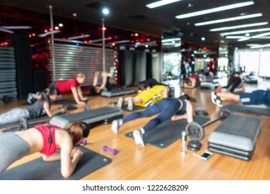 Blur Fitness class with group of people excercising with barbell, dumbbell - Powered by Shutterstock