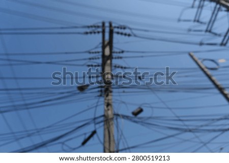 Blur focus of Cable whit blue sky.Power Lines and Clouds Against the Blue Sky - Contrast of Urban Infrastructure and Nature.