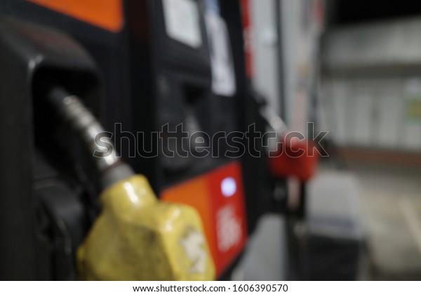 Blur focus of gas gun with car.Blur focus of\
Pump nozzles in a service station, Gas.Blur focus of Multi color\
fuel pistols on fuel\
station.
