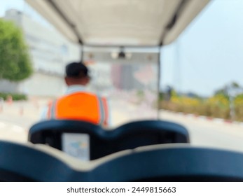 Blur focus of A man drives a golf cart on a sunny day. - Powered by Shutterstock