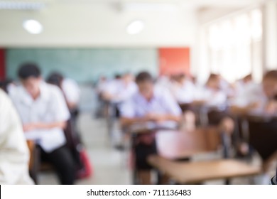 Blur Front View Background Examination Room.high School Or Undergraduate Student Inside.university Student In Uniform Sitting On Lecture Chair Taking Final Exam Or Study In Classroom.education Concept