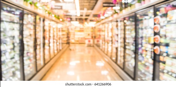 Blur Frozen Food Section At Retail Store In US. Huge Glass Door Aisle With Variety Pack Processed Fruit, Vegetable, Breakfast, Appetizer, Side, Meals , Pizza , Produce, Meat And Seafood.Panorama Style