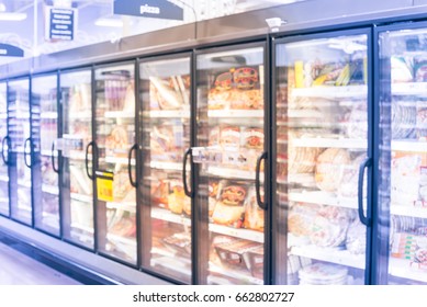 Blur Frozen Food Section At Retail Store In America. Huge Glass Door Aisle With Variety Pack Of Processed Pizza. Freezer Full Assortment Of Frozen Pizza In Local Supermarket Background. Vintage Tone.