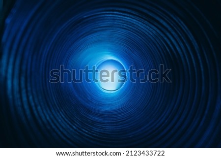 Blur glow background. Galaxy portal. Moonlight radiance. Defocused neon blue color lunar light sphere in ridged swirl texture tunnel on dark black.