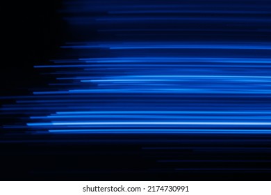 Blur glowing lines. Futuristic neon light. Cyber laser illumination. Defocused fluorescent navy blue color rays flare motion on dark black presentation abstract background.