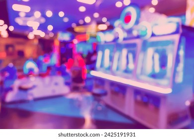 Blur image of arcade machine game for children game play in modern shopping mall,colorful neon lights.