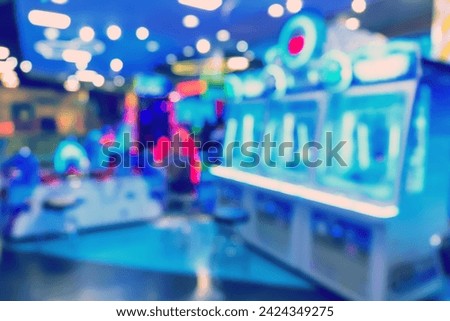 Blur image of arcade machine game for children game play in modern shopping mall,colorful neon lights.