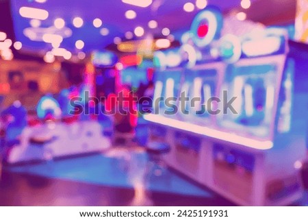 Blur image of arcade machine game for children game play in modern shopping mall,colorful neon lights.
