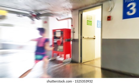 Blur Image Of Asian Girl Run To The Fire Exit Door In The Mall.