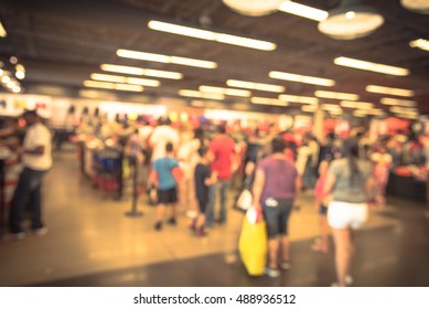 Blur Image Cashier With Long Line Of People Waiting At Checkout Counter In Fitness Store At Outlet Shopping Mall In Houston, Texas, US. Cashier Register And Payment Concept Background. Vintage Filter.