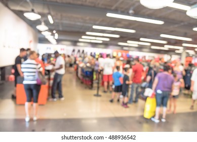 Blur Image Cashier With Long Line Of People Waiting At Checkout Counter In Fitness Store At Outlet Shopping Mall In Houston, Texas, US. Cashier Register And Checkout Payment Concept Background.