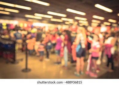 Blur Image Cashier With Long Line Of People Waiting At Checkout Counter In Fitness Store At Outlet Shopping Mall In Houston, Texas, US. Cashier Register And Payment Concept Background. Vintage Filter.