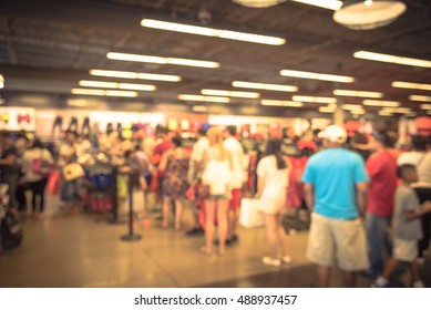 Blur Image Cashier With Long Line Of People Waiting At Checkout Counter In Fitness Store At Outlet Shopping Mall In Houston, Texas, US. Cashier Register And Payment Concept Background. Vintage Filter.