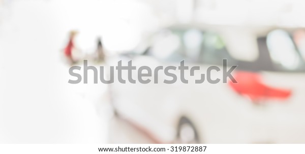 blur image of Commercially cars stand in show room\
of car shop.