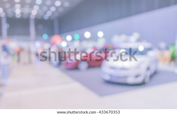 blur image of Commercially cars stand\
in show room of car shop for background\
usage.