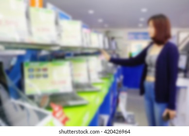 Blur Image Of Computer Notebook Store, Asian Girl Customer Choosing Laptop In Consumer Electronics Store