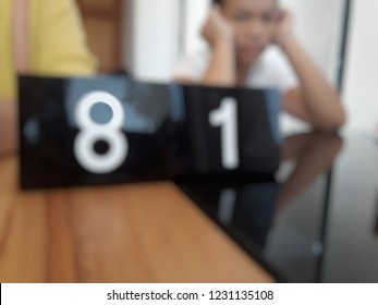 Blur Image Cue Card On Wooden Table With A Girl Sitting On The Chair In Restaurant