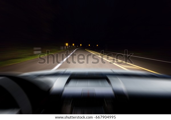 Blur\
image of dark road in the forest as\
background.