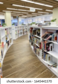 Blur image of empty public library. Curved bookshelves.
