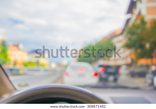 blur image of inside car in the\
city to see the road with bokeh lights for background\
usage.