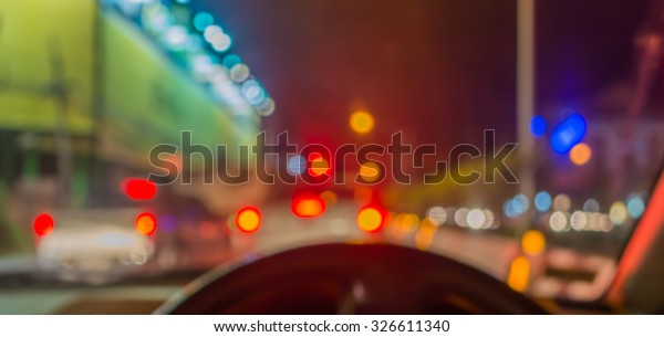 blur image of inside cars with\
bokeh lights with traffic jam on night time for background\
usage.