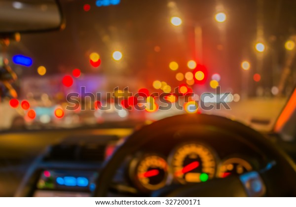 blur image of inside cars with
bokeh lights with traffic jam on night time for background
usage.