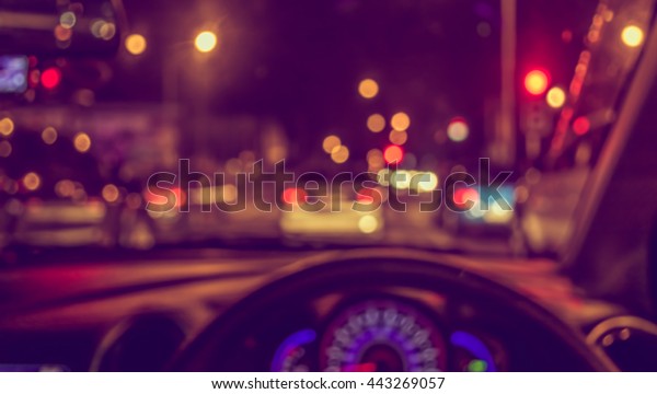 blur image of inside cars with\
bokeh lights with traffic jam on night time for background\
usage.