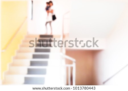 Blur image of mother carried the baby down the stairs.