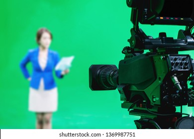 Blur Image Of Newscaster Or Announcer Preparing To Record Program In Broadcast Television Virtual Greenscreen Studio Room With Professional Cameras.