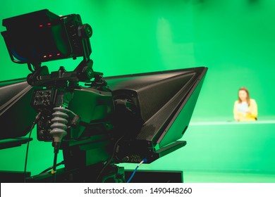 Blur Image Of Newscaster Or Announcer Preparing To Record Program In Broadcast Television Virtual Greenscreen Studio Room With Professional Cameras.