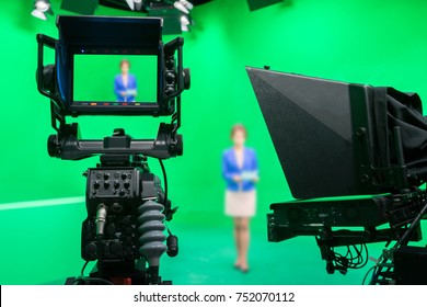 Blur Image Of Newscaster Or Announcer Preparing To Record Program In Broadcast Television Virtual Greenscreen Studio Room With Professional Cameras.