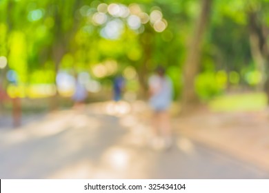 Blur image of people activities in park with bokeh on day time for background usage.
