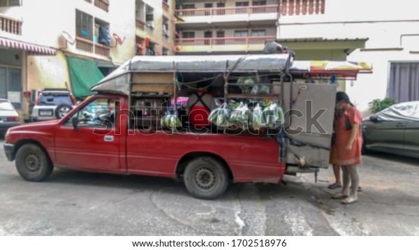 Blur image people buying\
vegetable  in plastic hanging on car,grocery truck,Truck vegetable\
shop.