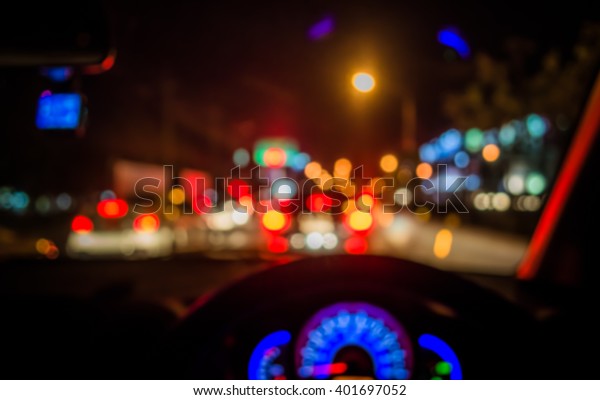 blur image of people\
driving car on night time for background usage.(take photo from\
inside)