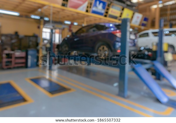 blur image of worker fixing car in the garage for\
background usage.