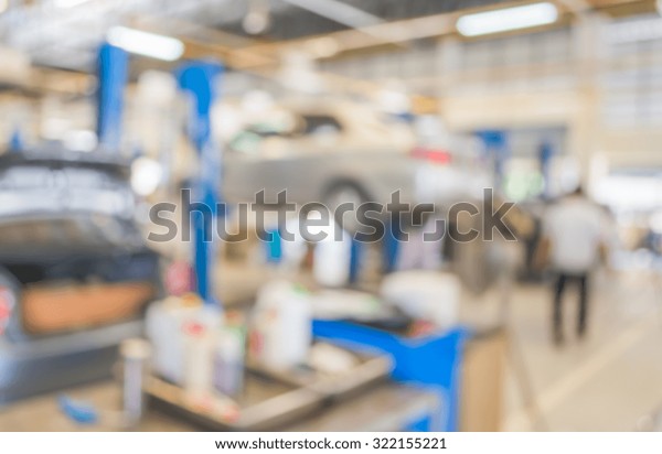 blur image of worker fixing car in ther garage for
background usage.