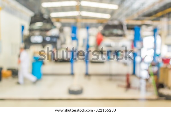 blur image of worker fixing car in ther garage for\
background usage.