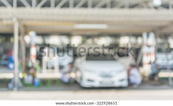blur image of worker fixing car in the garage for\
background usage.