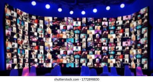 Blur large LED screen show many people's faces join big online event or virtual reality live conference. Big video call seminar, Work from home, Social distancing, New normal event production.