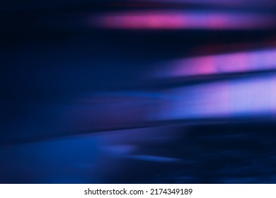Blur light flare. Bokeh neon glow. Futuristic radiance. Defocused ultraviolet navy blue pink purple color flecks glare on dark modern abstract background.