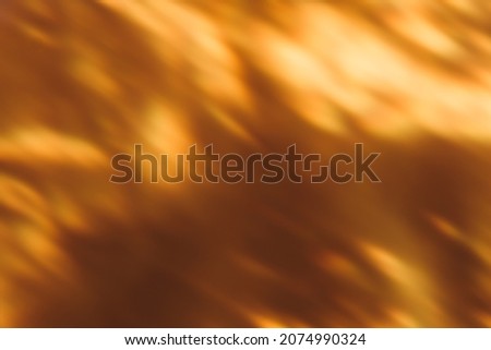 Blur light overlay. Bokeh glow. Solar burst. Fall sunlight reflection. Defocused golden orange black flecks pattern abstract background.