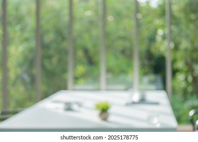 Blur Meeting Room Table In Office Background With See Through Window To Tree In Garden In Morning With No People.buisness Backdrop