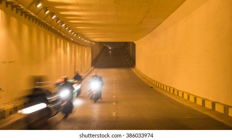 Blur motion group of people riding motorcycles thru a traffic tunnel in Hanoi in early morning. This is the most popular vehicle in Vietnam. Urban traffic concept. Transportation background. - Powered by Shutterstock