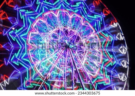 Blur motion of light Ferris wheel. Long exposure light at night fun park, merry go around.