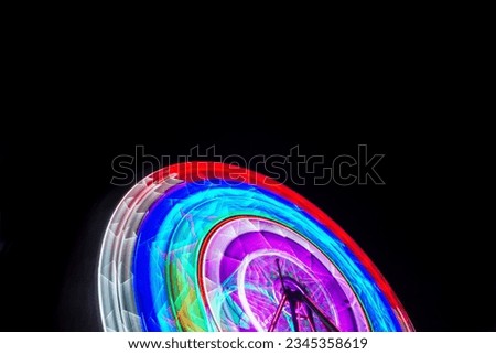 Blur motion of light Ferris wheel. Long exposure light at night fun park, merry go around.