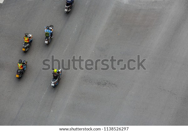 Blur motion people on\
motorcycles are moving on road, Aerial top view shot, selective\
focus at road.